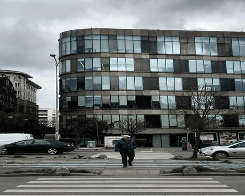 Urban pedestrian walking near a modern building